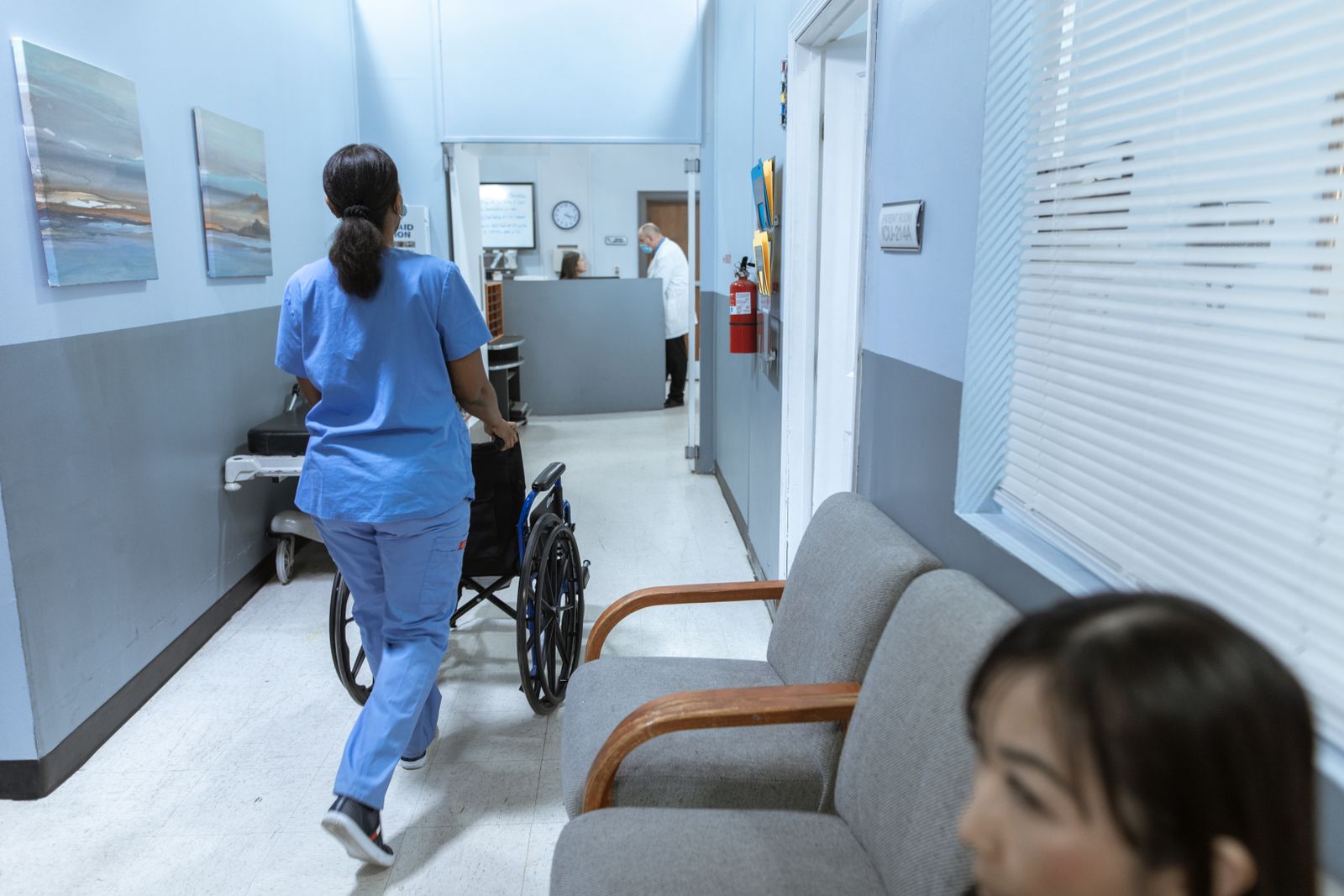 A nurse walking through a bright clinic corridor