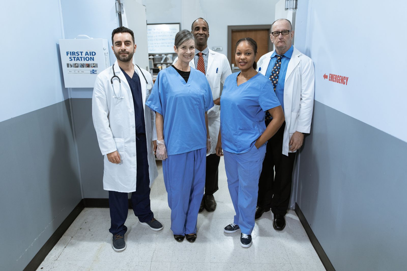 Healthcare professionals in conversation in a clinic corridor