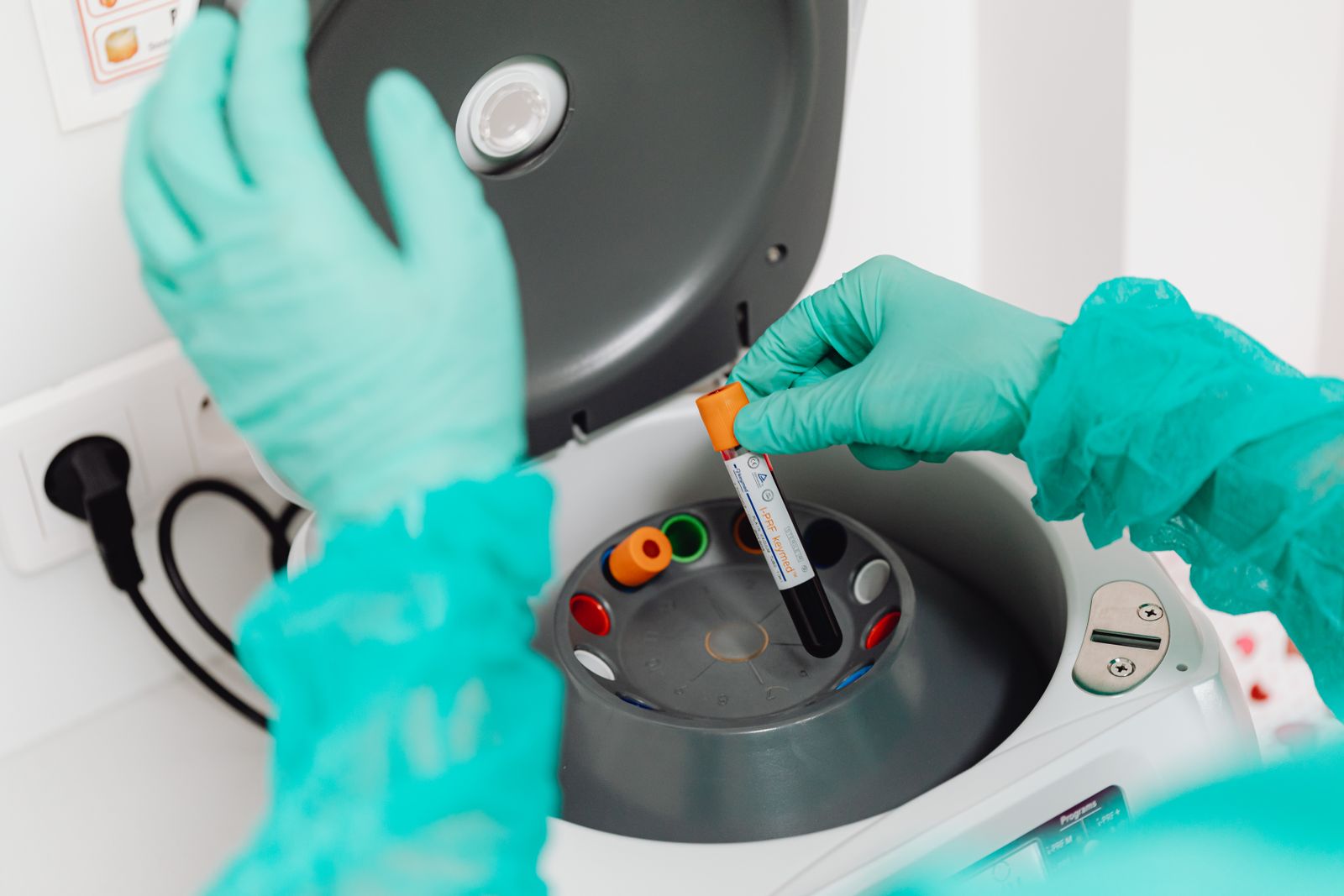 A laboratory technician handling blood sample tubes